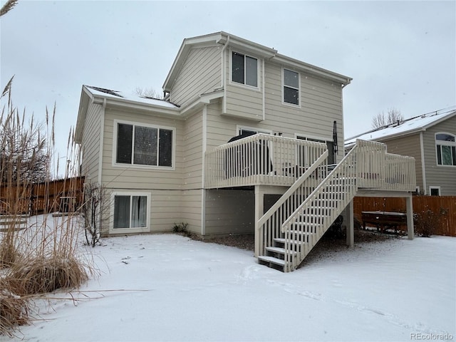 snow covered house with a deck