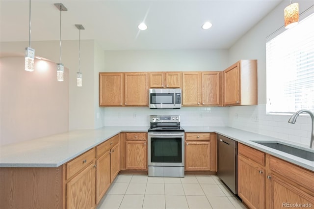 kitchen with a sink, a peninsula, a healthy amount of sunlight, stainless steel appliances, and decorative backsplash