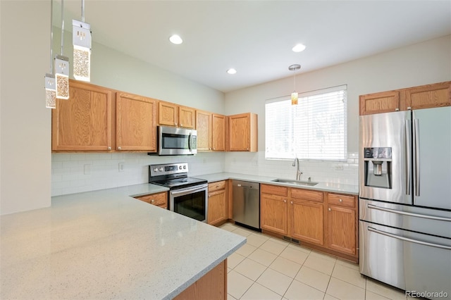 kitchen featuring visible vents, a sink, stainless steel appliances, decorative light fixtures, and backsplash