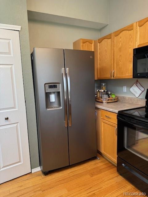 5201 E 127th Dr, Thornton, CO 80241 - kitchen featuring black appliances, light countertops, and light wood-style floors