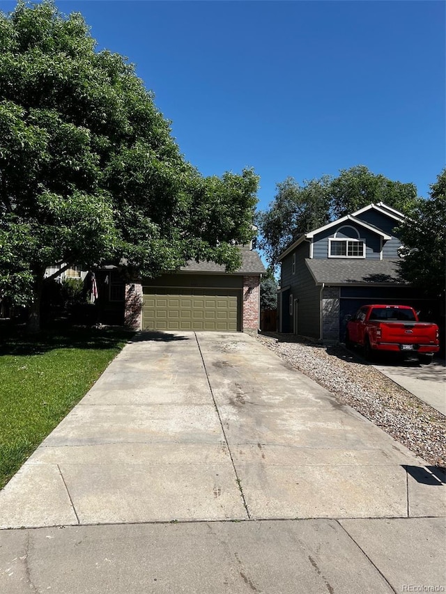 5201 E 127th Dr, Thornton, CO 80241 - view of front of home with driveway, brick siding, and an attached garage