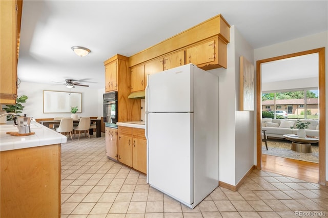 7135 S Sherman St, Centennial, CO 80122 - kitchen with freestanding refrigerator, light tile patterned flooring, oven, a ceiling fan, and tile counters