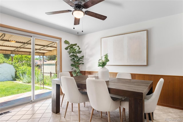 7135 S Sherman St, Centennial, CO 80122 - dining space featuring wainscoting, light tile patterned floors, wood walls, and a ceiling fan