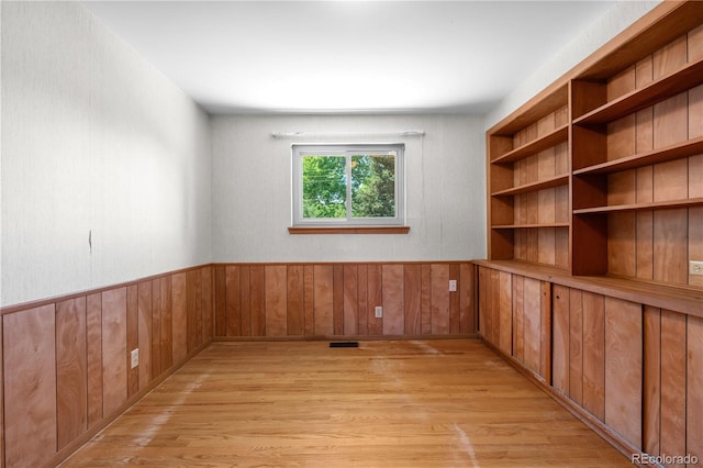 7135 S Sherman St, Centennial, CO 80122 - empty room with light wood-style floors, wood walls, and a wainscoted wall