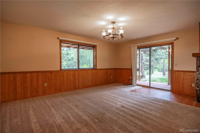 917 Bluebird Ln, Bailey, CO 80421 - tiled empty room with wainscoting, wood walls, a chandelier, and healthy amount of natural light