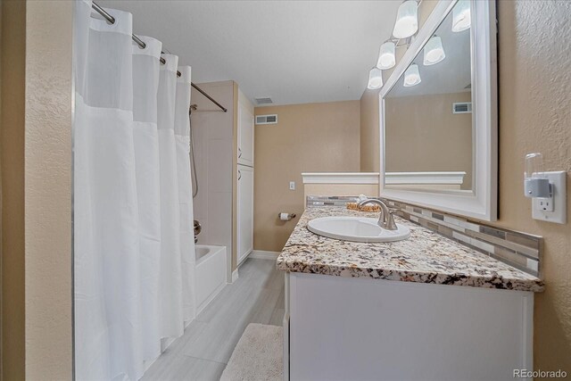 10127 W 100th Ct, Westminster, CO 80021 - full bathroom with shower / bath combination with curtain, vanity, baseboards, and tasteful backsplash