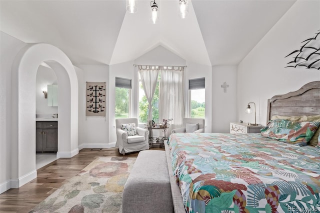 1588 W 111th Ave, Northglenn, CO 80234 - bedroom with wood finished floors, vaulted ceiling, ensuite bathroom, and arched walkways
