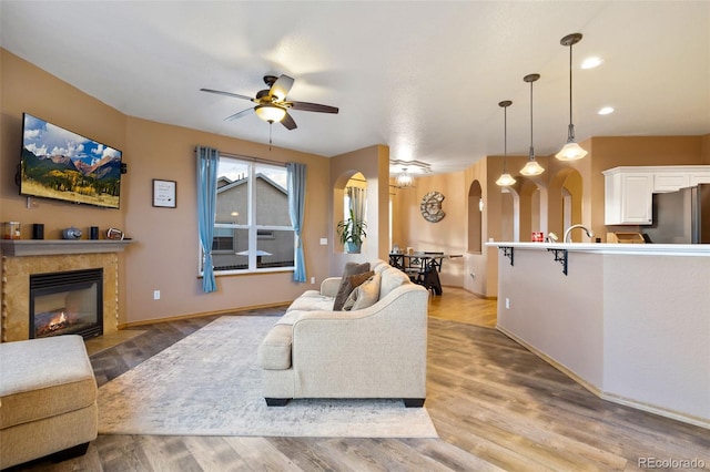 living room with ceiling fan and light hardwood / wood-style floors