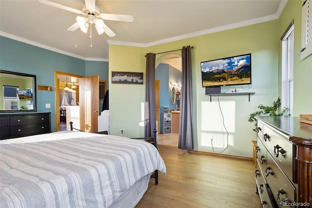 bedroom featuring ornamental molding, light wood-type flooring, ceiling fan, and a closet