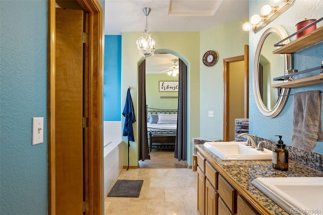 bathroom with vanity, tile patterned floors, ceiling fan, and tiled tub