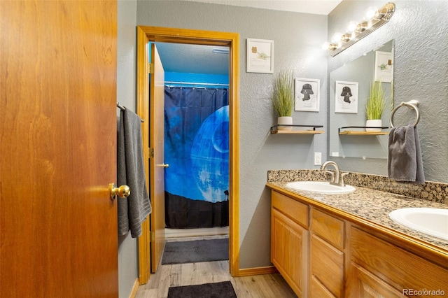 bathroom with curtained shower, vanity, and hardwood / wood-style flooring