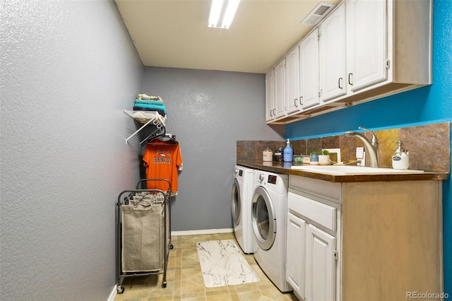 laundry room featuring cabinets, sink, and washing machine and clothes dryer