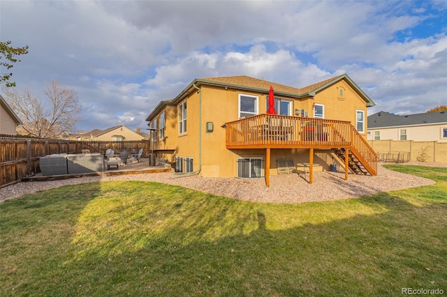 rear view of house with a deck, a patio, central AC, and a yard