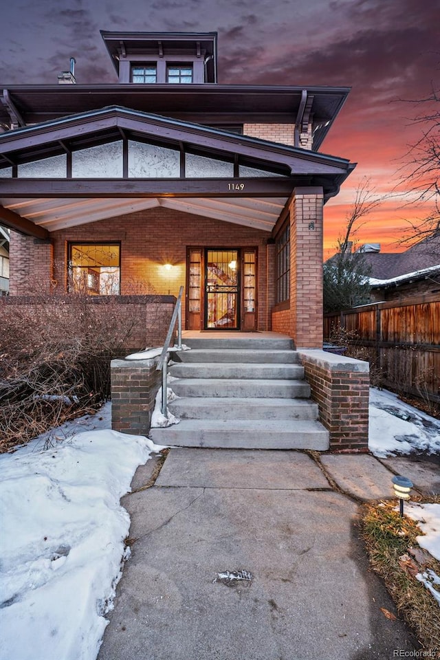 exterior entry at dusk with covered porch