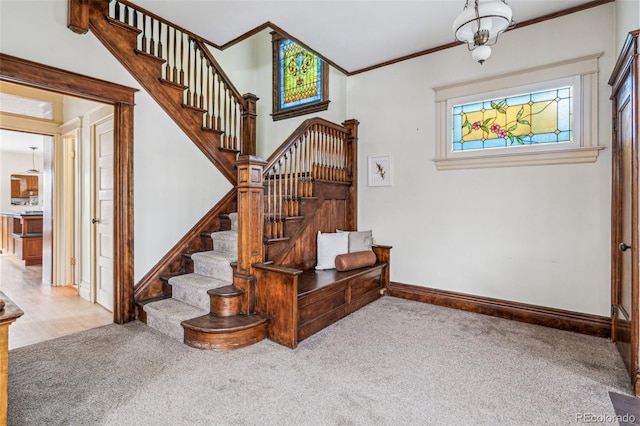 carpeted entryway with ornamental molding