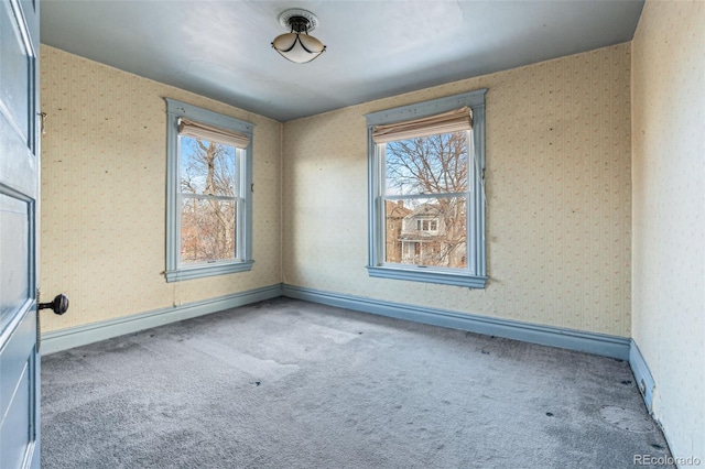 carpeted empty room with a baseboard heating unit