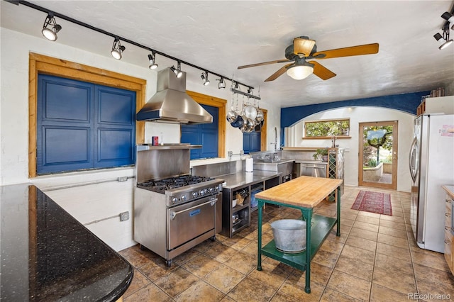 1069 Crestmoor Dr, Boulder, CO 80303 - kitchen with island exhaust hood, appliances with stainless steel finishes, rail lighting, ceiling fan, and blue cabinets