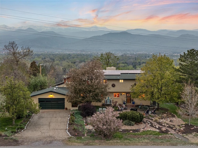 1069 Crestmoor Dr, Boulder, CO 80303 - view of front facade with stucco siding, asphalt driveway, a mountain view, and solar panels