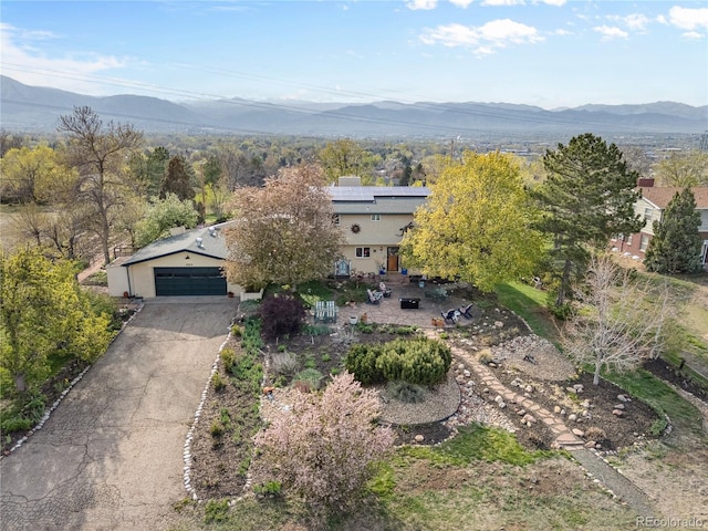1069 Crestmoor Dr, Boulder, CO 80303 - view of front of home featuring roof mounted solar panels, a mountain view, a detached garage, and stucco siding