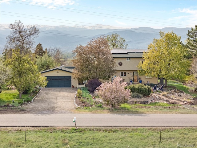 1069 Crestmoor Dr, Boulder, CO 80303 - view of property hidden behind natural elements with stucco siding, solar panels, a mountain view, and driveway