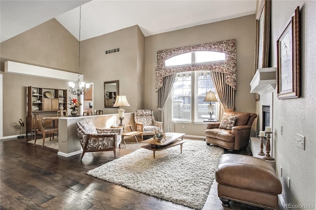 living area with a fireplace, an inviting chandelier, dark wood-type flooring, and high vaulted ceiling