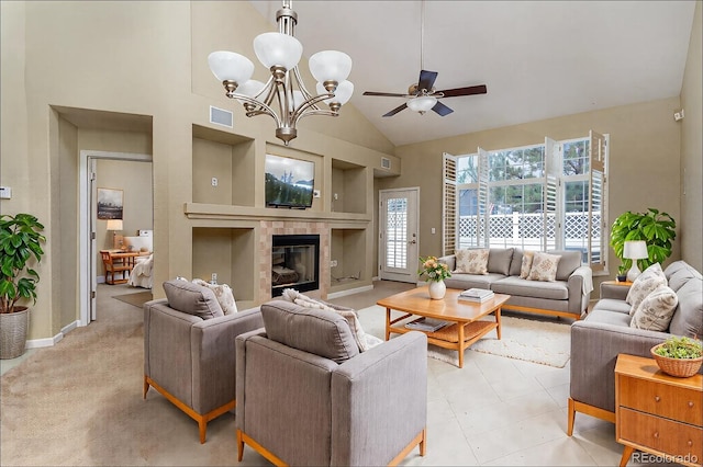 living area featuring high vaulted ceiling, a healthy amount of sunlight, visible vents, and a tiled fireplace