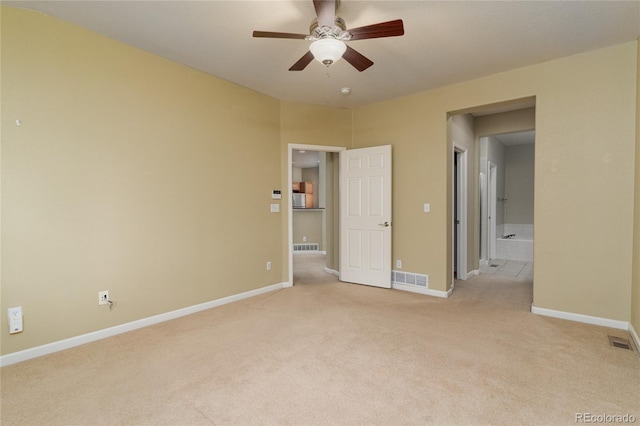 unfurnished bedroom featuring baseboards, visible vents, connected bathroom, and light colored carpet