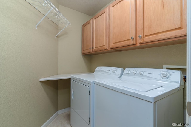 laundry area featuring baseboards, cabinet space, and washer and dryer