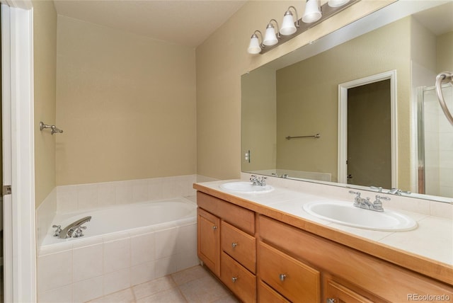 full bathroom featuring a garden tub, double vanity, a sink, and tile patterned floors