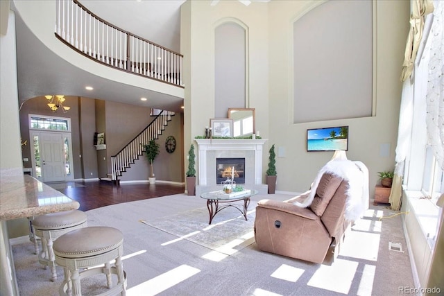 6254 S Riviera Ct, Aurora, CO 80016 - living room featuring a high ceiling, healthy amount of natural light, stairs, and baseboards