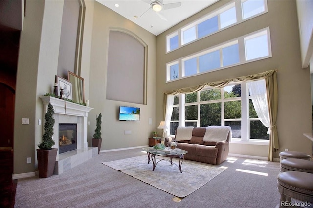 6254 S Riviera Ct, Aurora, CO 80016 - living room featuring carpet, a high ceiling, a glass covered fireplace, ceiling fan, and baseboards