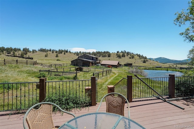 wooden deck featuring a rural view and a water view