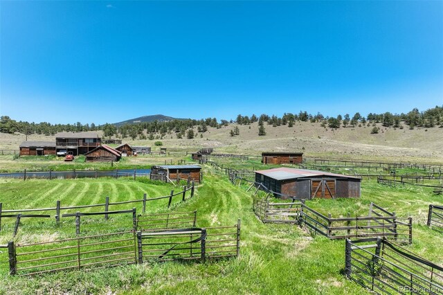 view of yard featuring a rural view and an outbuilding