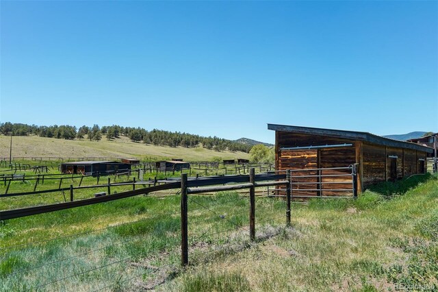 view of yard with a rural view and an outbuilding