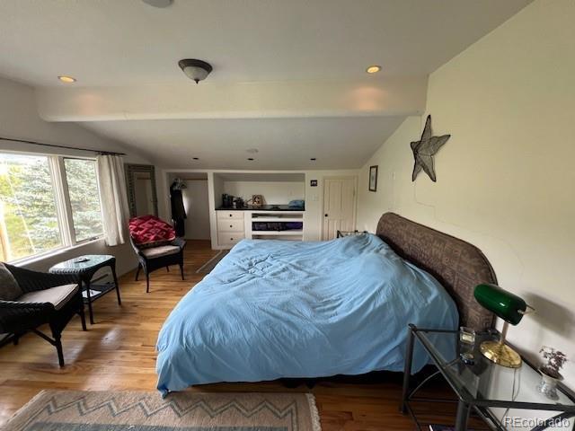 bedroom featuring hardwood / wood-style flooring and lofted ceiling