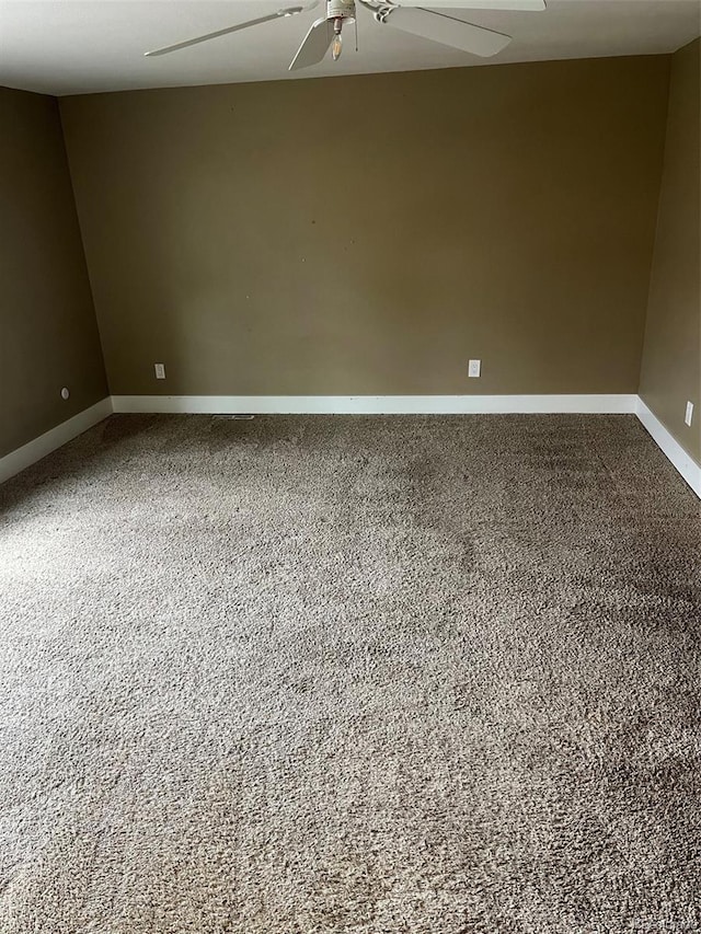 empty room with a ceiling fan, carpet flooring, and baseboards