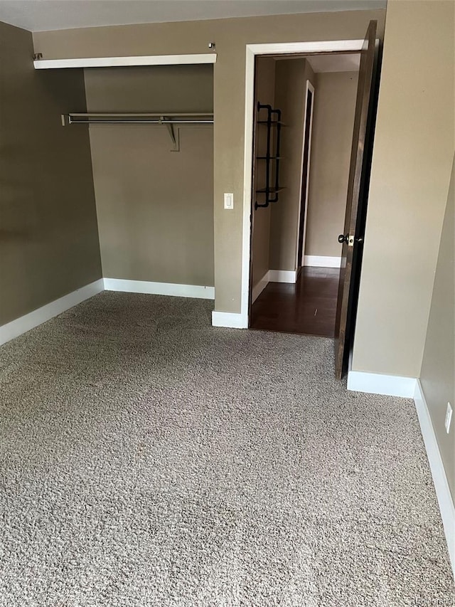 unfurnished bedroom with a closet, baseboards, and carpet floors