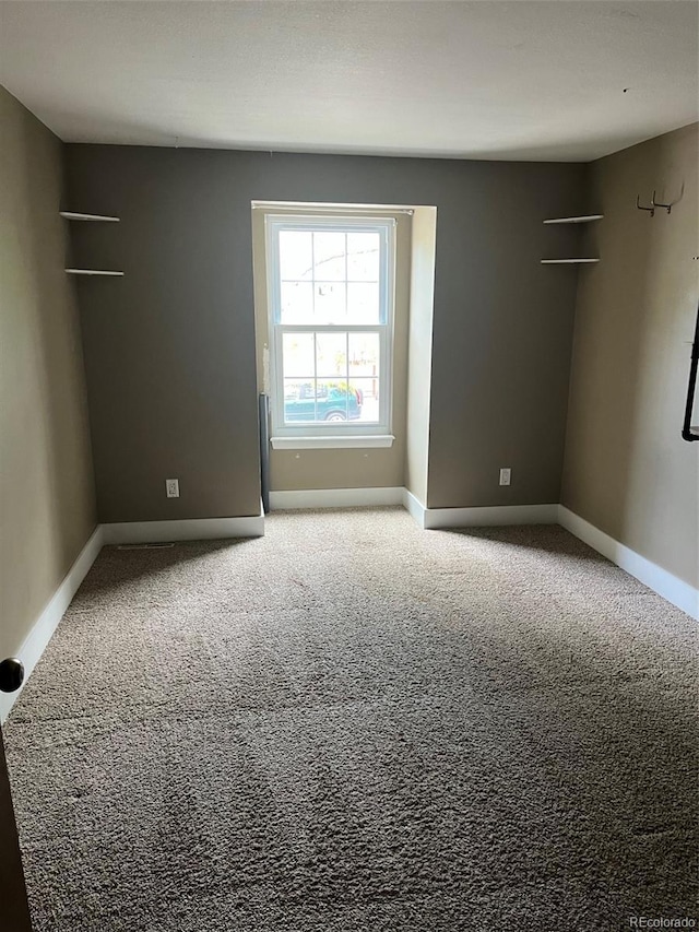 unfurnished room with carpet floors and baseboards