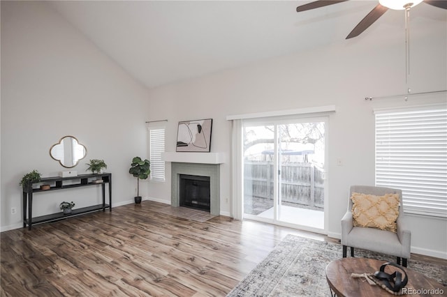 living area featuring hardwood / wood-style flooring, ceiling fan, and high vaulted ceiling