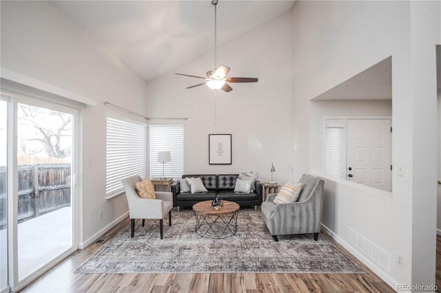 living room featuring ceiling fan, wood-type flooring, and high vaulted ceiling