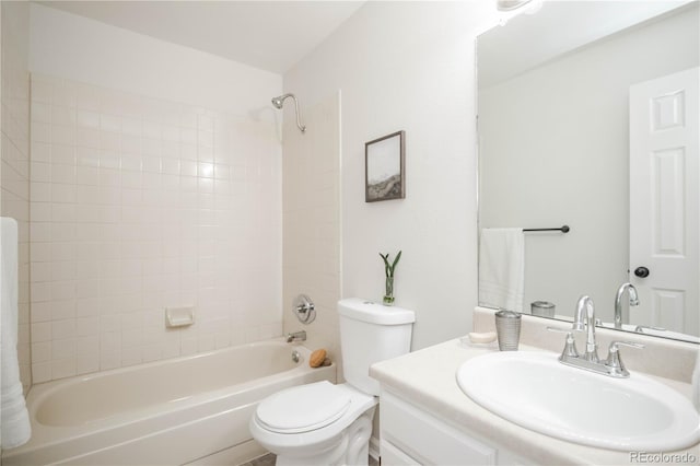 full bathroom with tiled shower / bath, vanity, and toilet