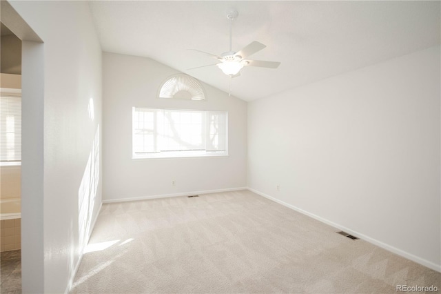 spare room with lofted ceiling, light colored carpet, and ceiling fan