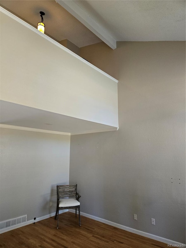 unfurnished room featuring vaulted ceiling with beams, wood finished floors, visible vents, and baseboards