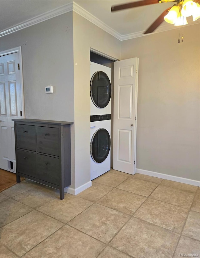 laundry area with laundry area, ornamental molding, stacked washing maching and dryer, and baseboards