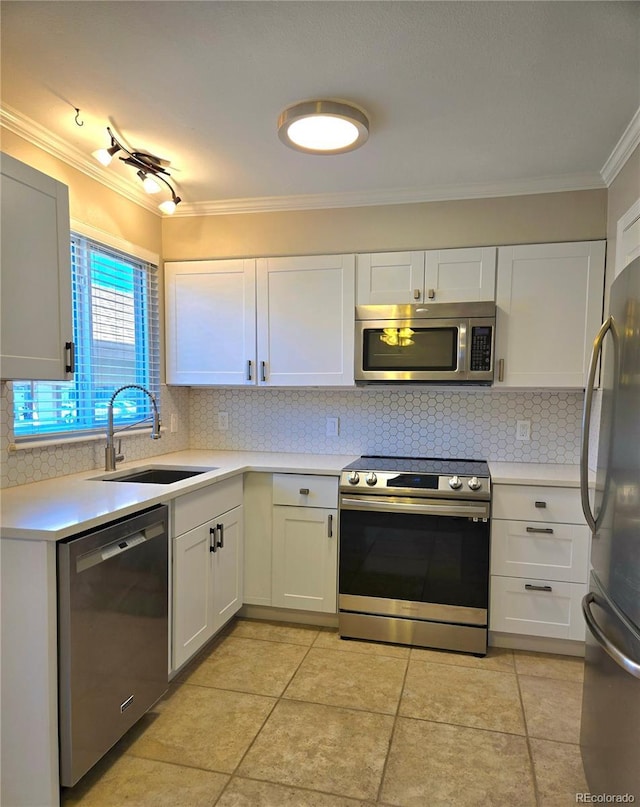 kitchen with a sink, stainless steel appliances, crown molding, light countertops, and backsplash