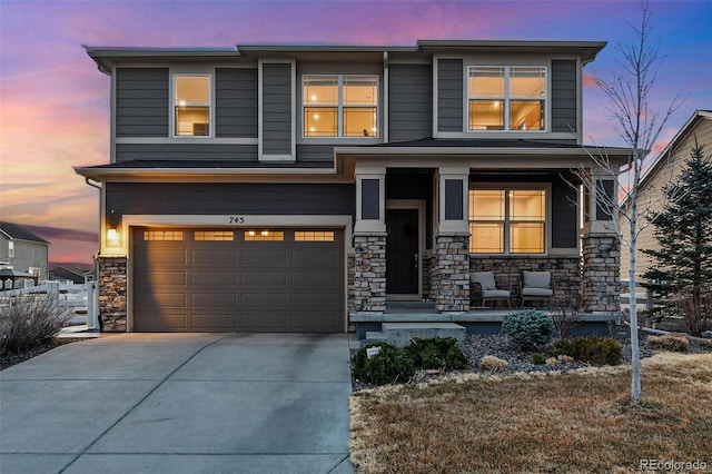 view of front of house with stone siding, an attached garage, concrete driveway, and a porch