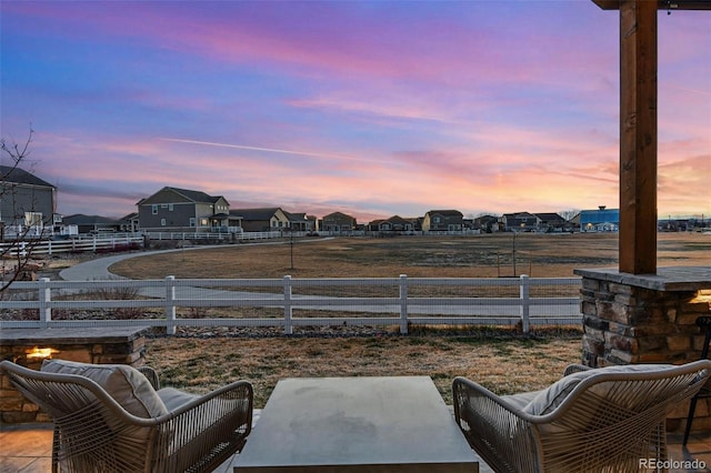 patio terrace at dusk with a residential view and fence