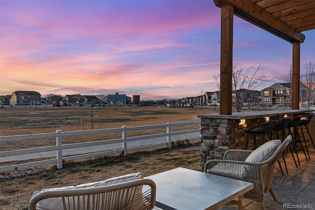 view of patio / terrace featuring a residential view, outdoor dining area, and fence
