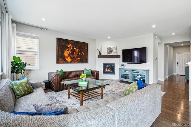 living room featuring baseboards, a fireplace, wood finished floors, and recessed lighting