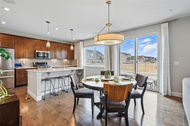 dining space featuring baseboards, dark wood-style flooring, and recessed lighting